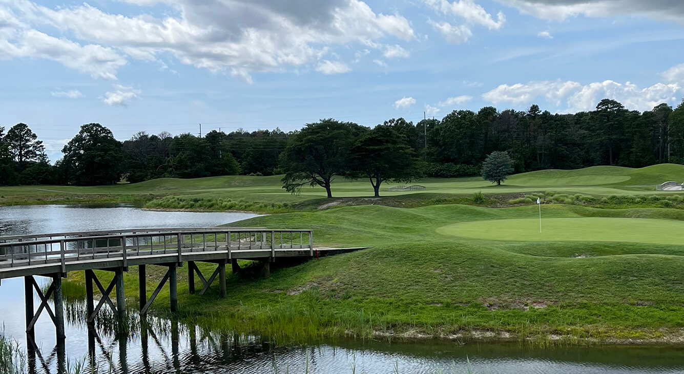 wood bridge leading to golf green